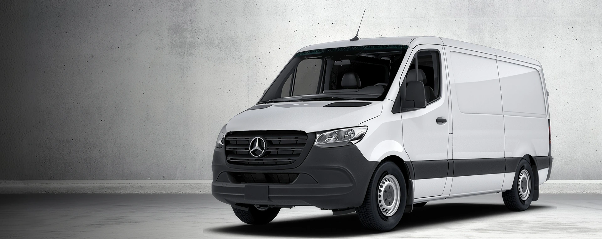 White 2026 Mercedes-Benz Sprinter Cargo Van parked in front of a bare concrete wall
