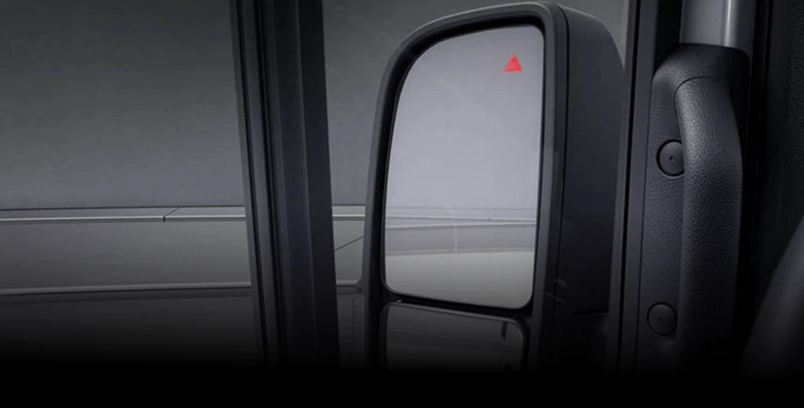 Sprinter side mirror with a red Blind Spot Assist warning triangle lit in the corner of the glass