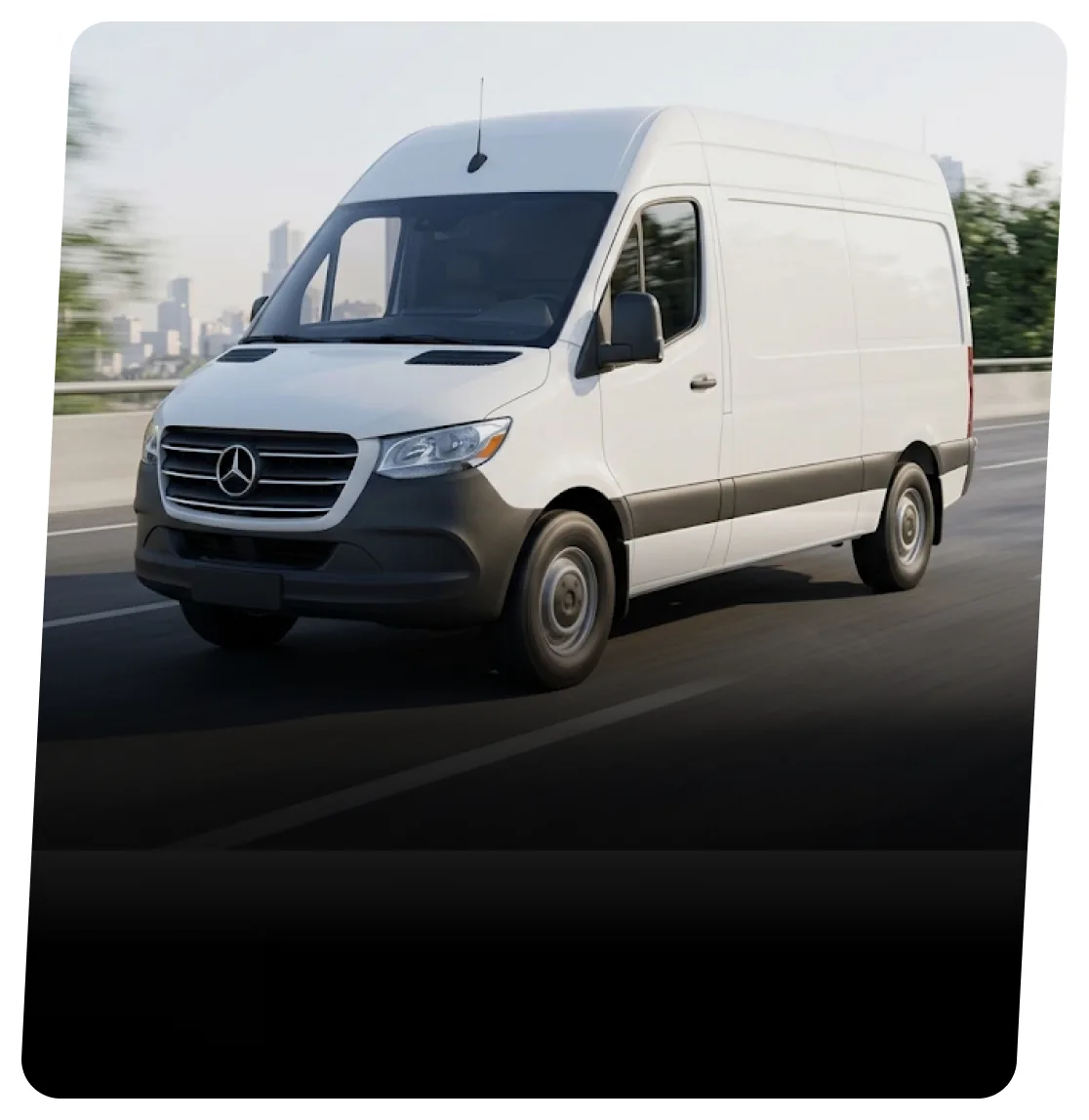 White Mercedes-Benz Sprinter van on a highway with a city skyline behind