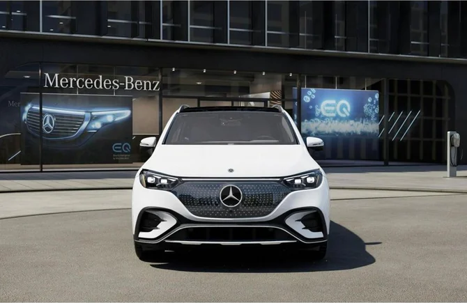 A white Mercedes-Benz EQE SUV parked head-on outside a Mercedes-Benz EQ showroom