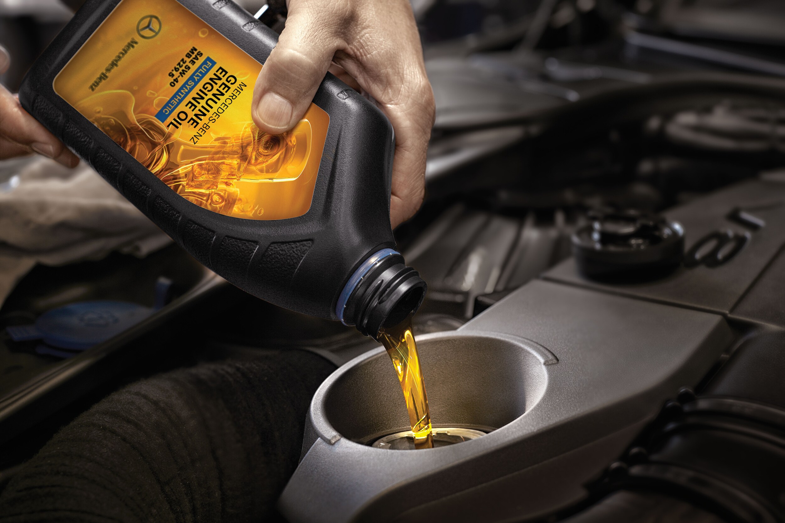 mercedes-benz service technician changing the oil in a car