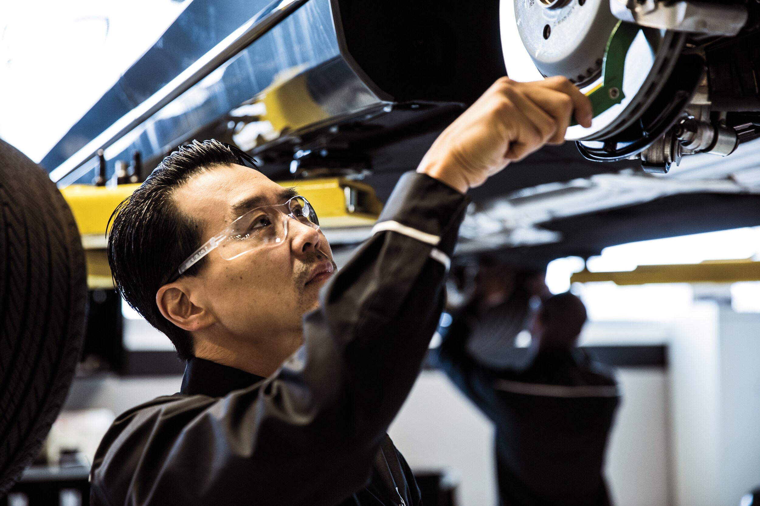 mercedes-benz service technician checking the brakes on a car