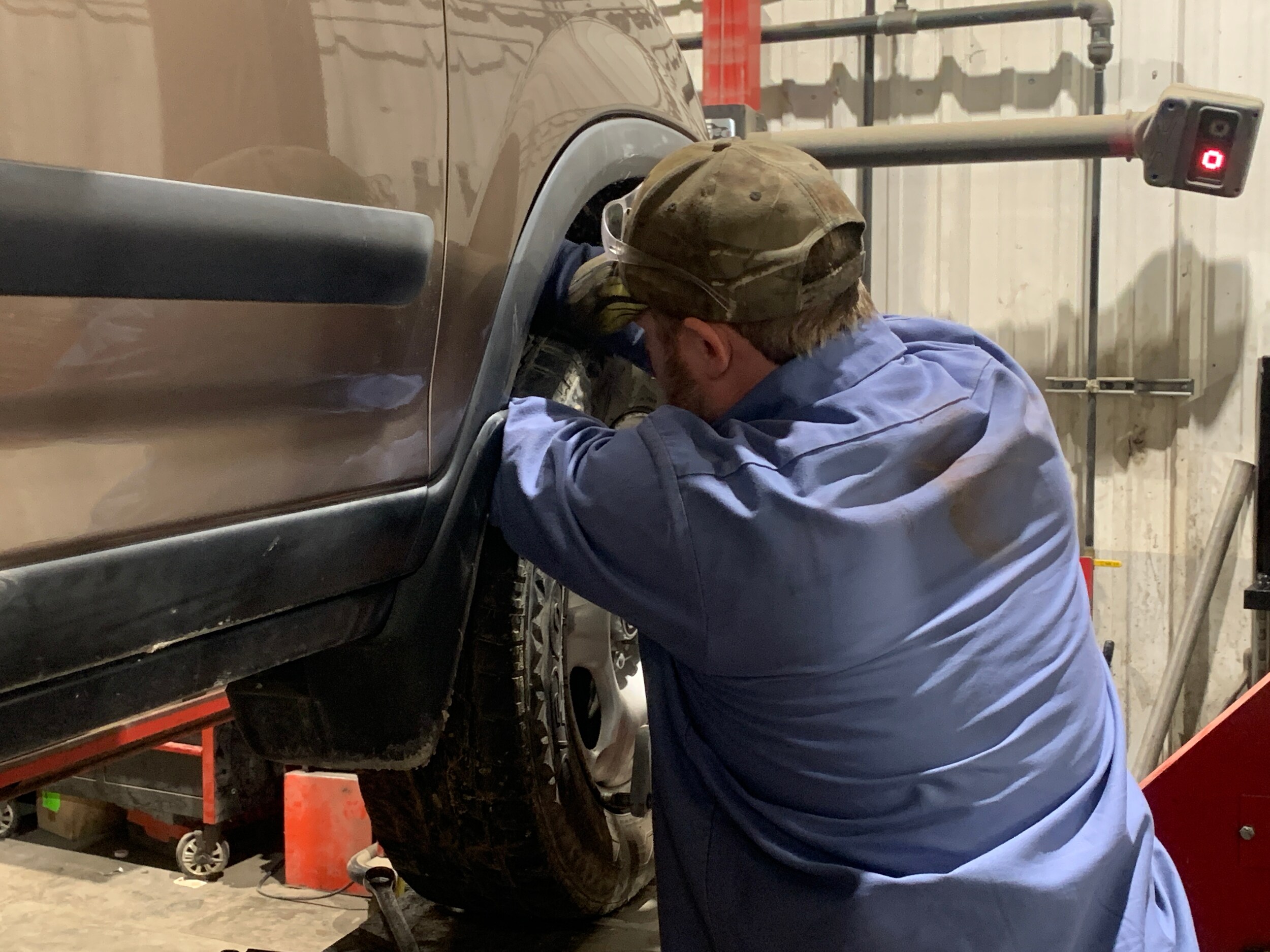 Service technician Nick Shue works on tire alignment