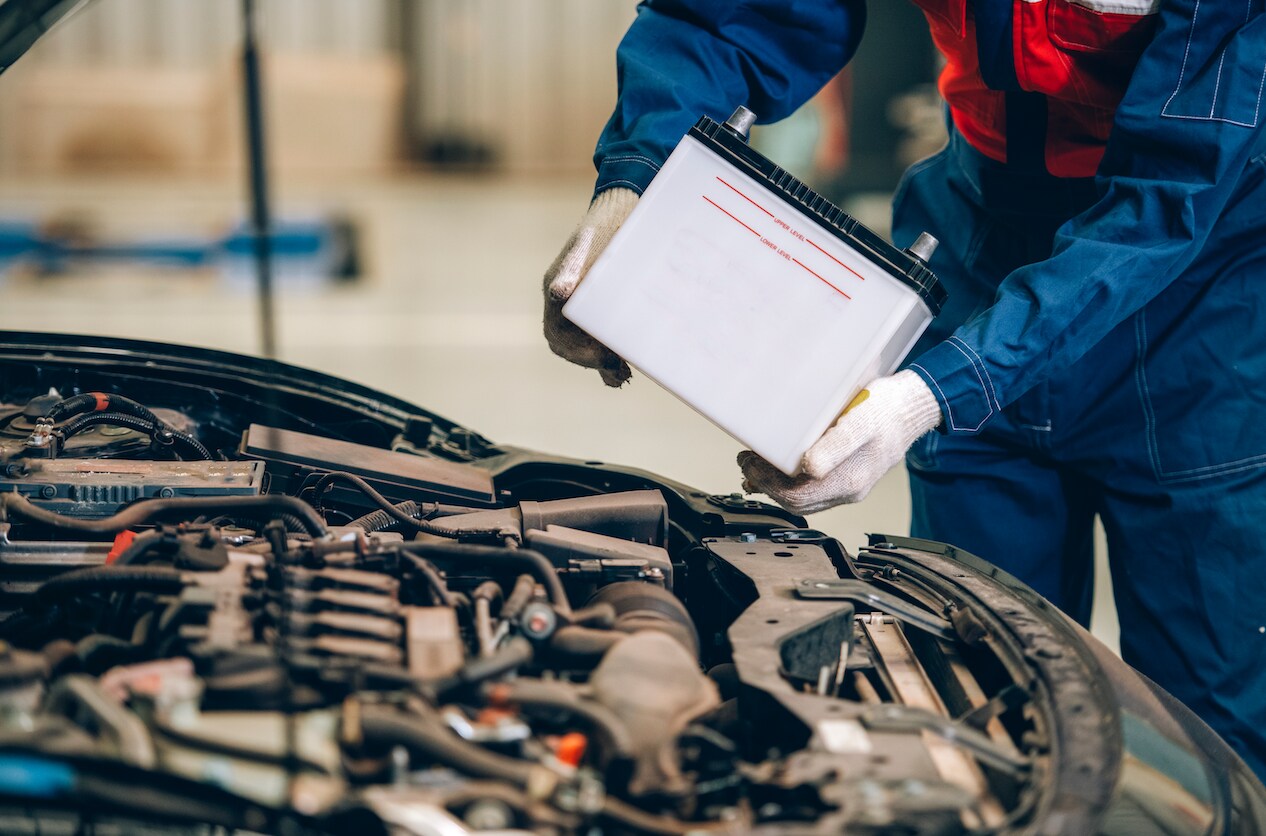 Mechanic replacing a battery at a service center.