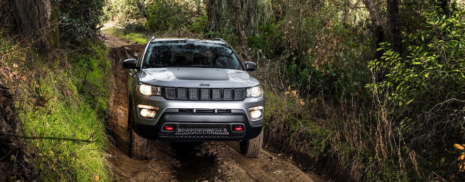 2018 Jeep Compass driving through a dirt trail
