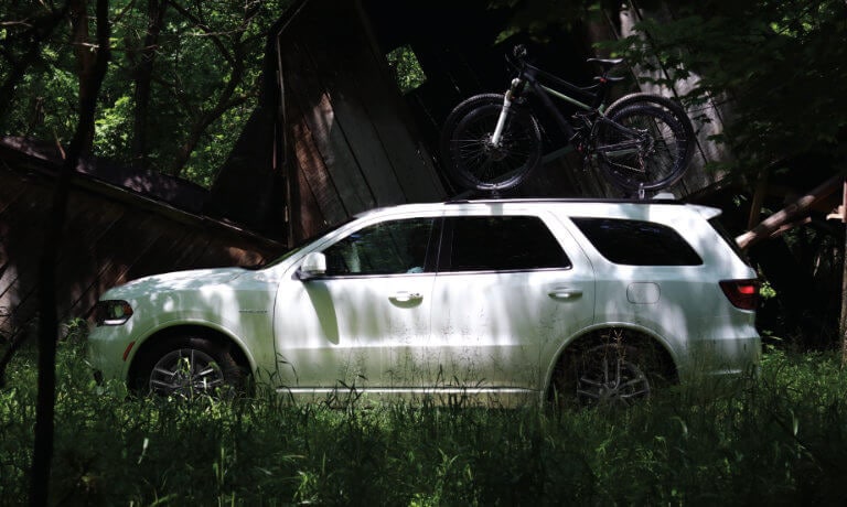 2023 Dodge Durango parked in a forest with bikes