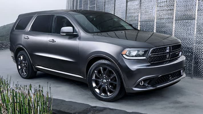 Dodge Durango A silver Dodge Durango parked in front of a metal wall