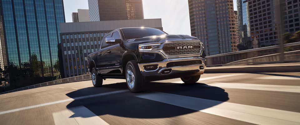 Ram 1500 A black Ram 1500 driving through a city street