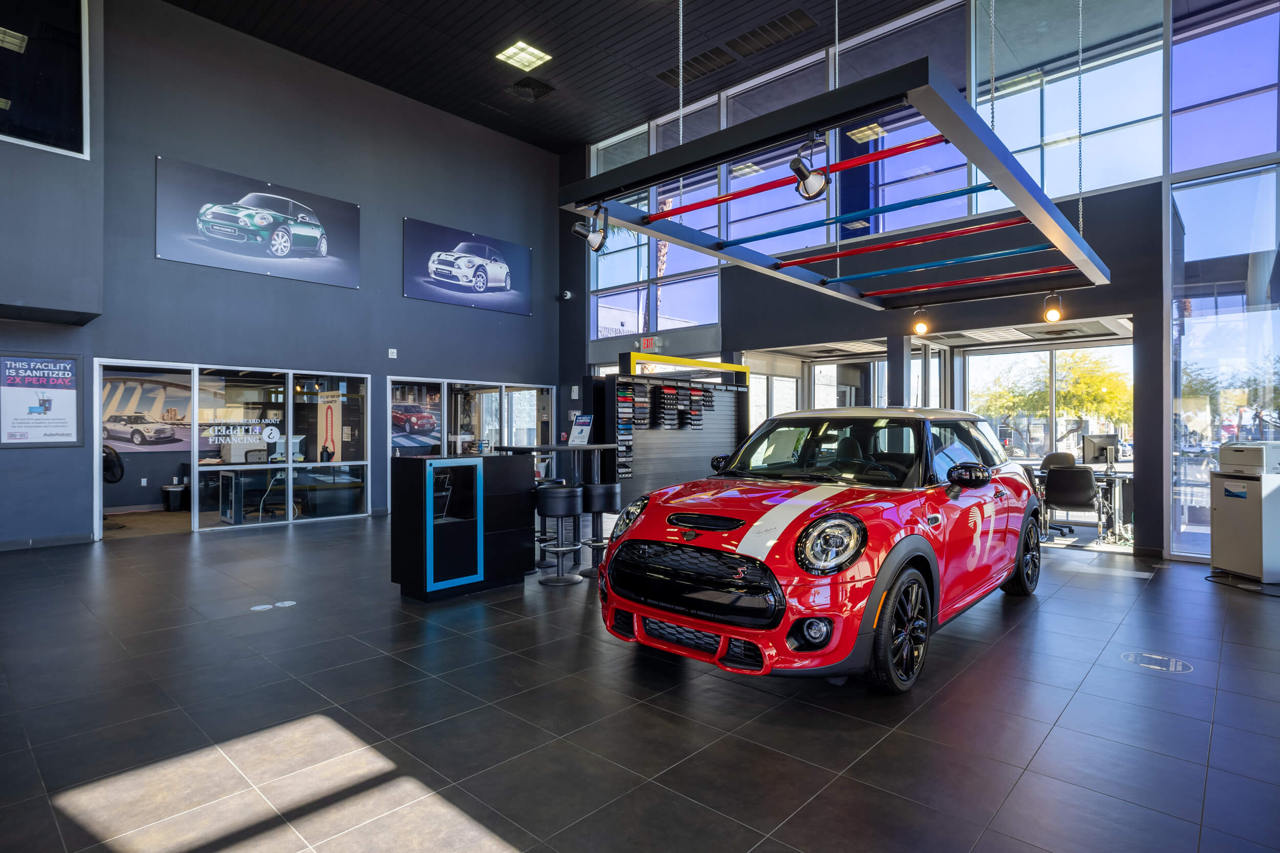 Find out about financing at MINI of Las Vegas Red MINI with a white stripe on the hood inside MINI of Las Vegas
