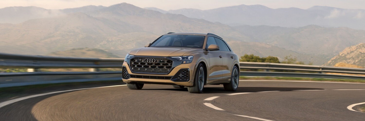 Audi Q8 Gold Q8 Premium on a curvy highway