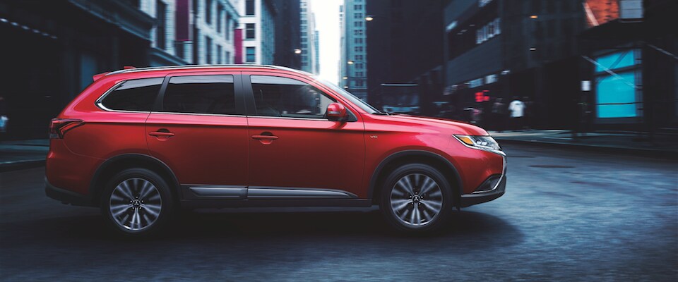 Red Mitsubishi Outlander A red 2019 Mitsubishi Outlander driving through a city