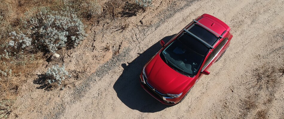 Red Mitsubishi Outlander Sport driving in the desert Birds Eye View of a red Mitsubishi Outlander Sport driving in a desert