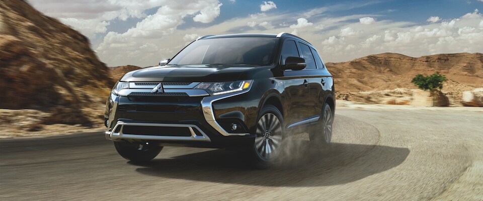 Black Mitsubishi Outlander A black 2019 Mitsubishi Outlander GT driving through desert