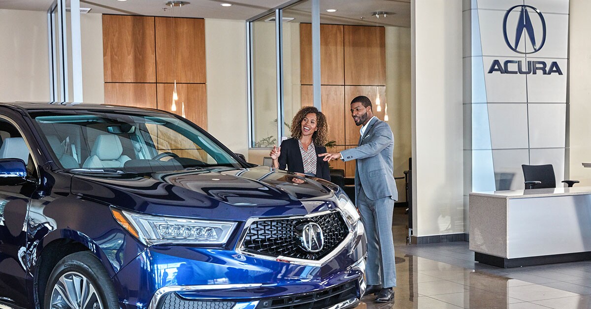 Acura_Dealership_SalesPerson_3_1200x628.jpg Acura finance consultation taking place inside a showroom
