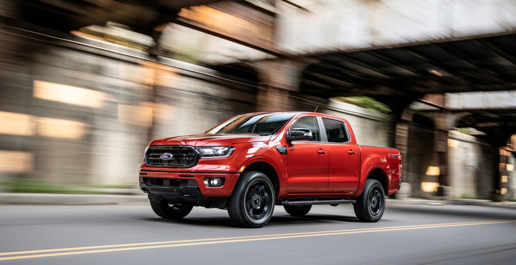 2020 Ford Range Lariat SuperCrew Truck red driving under overpass on road_hor.jpeg