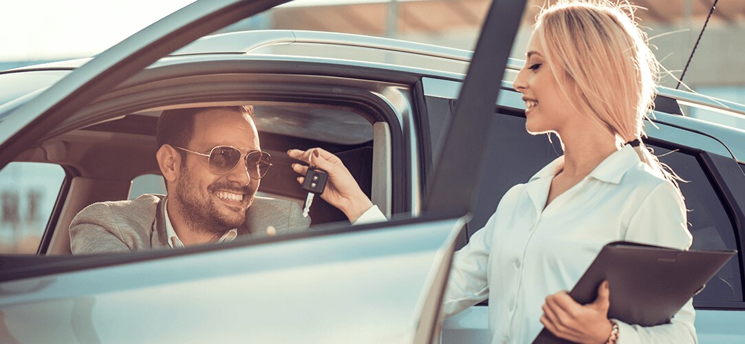 man getting keys to a new car