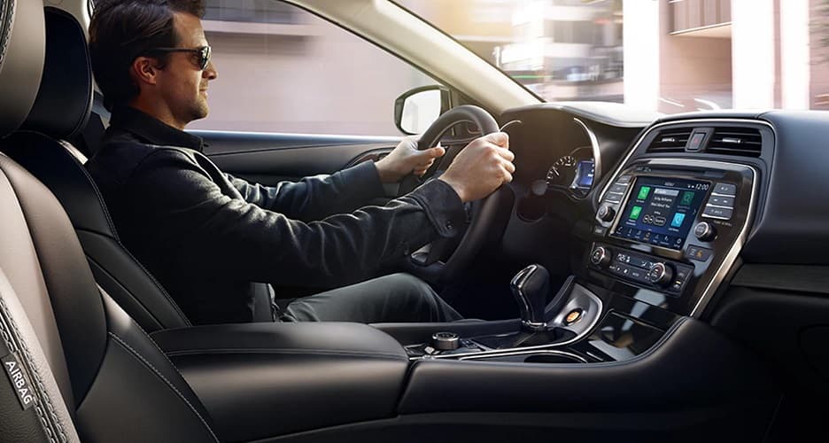 Interior view of man driving Nissan Maxima