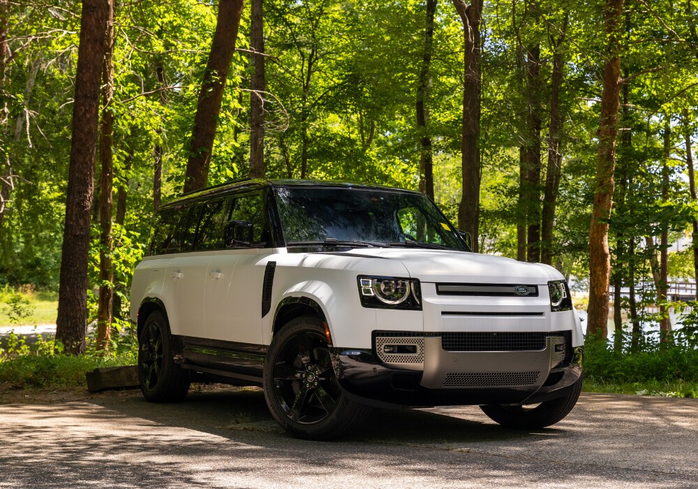 defender-130-for-sale.png White 2025 Defender 130 for sale parked in front of a wooded area