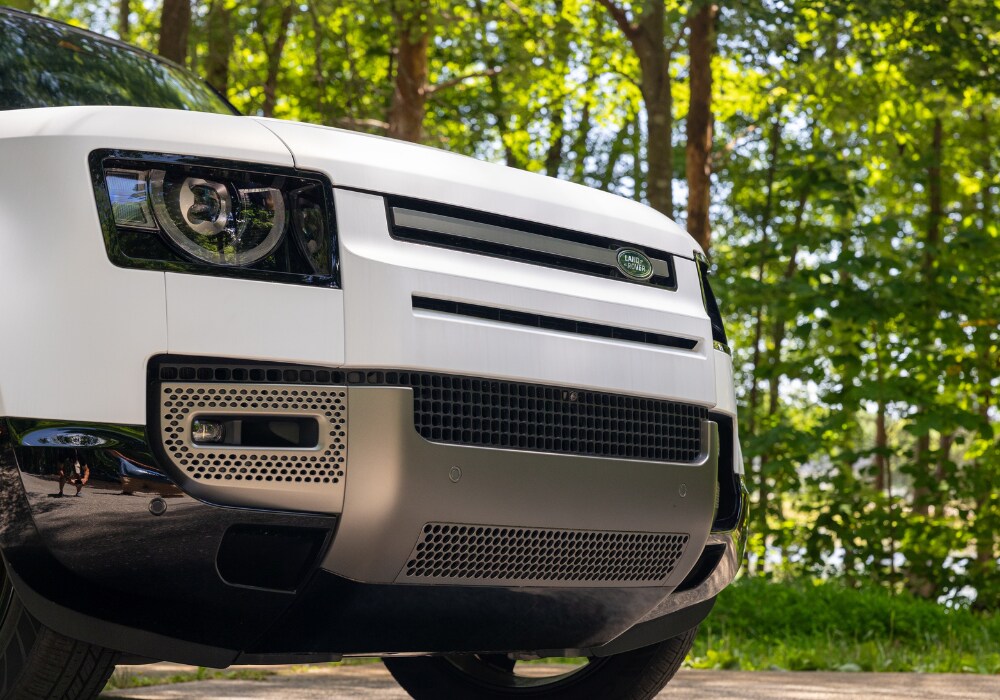 land-rover-dealership-serving-winston-salem.png Close up photo of a Land Rover car parked outside with trees in the background