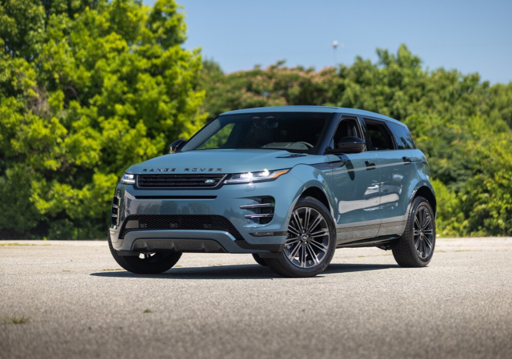 range-rover-evoque-for-sale.png 2025 Range Rove Evoque parked in a lot with trees in the background. The Range Rover SUV is blue