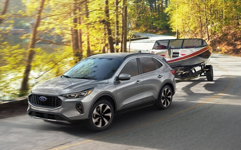Ford Escape circulando por una ruta panorámica transportando un barco