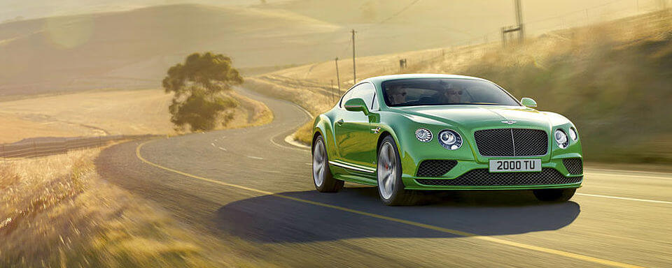 Certified pre-owned Bentley Continental GT driving down a road