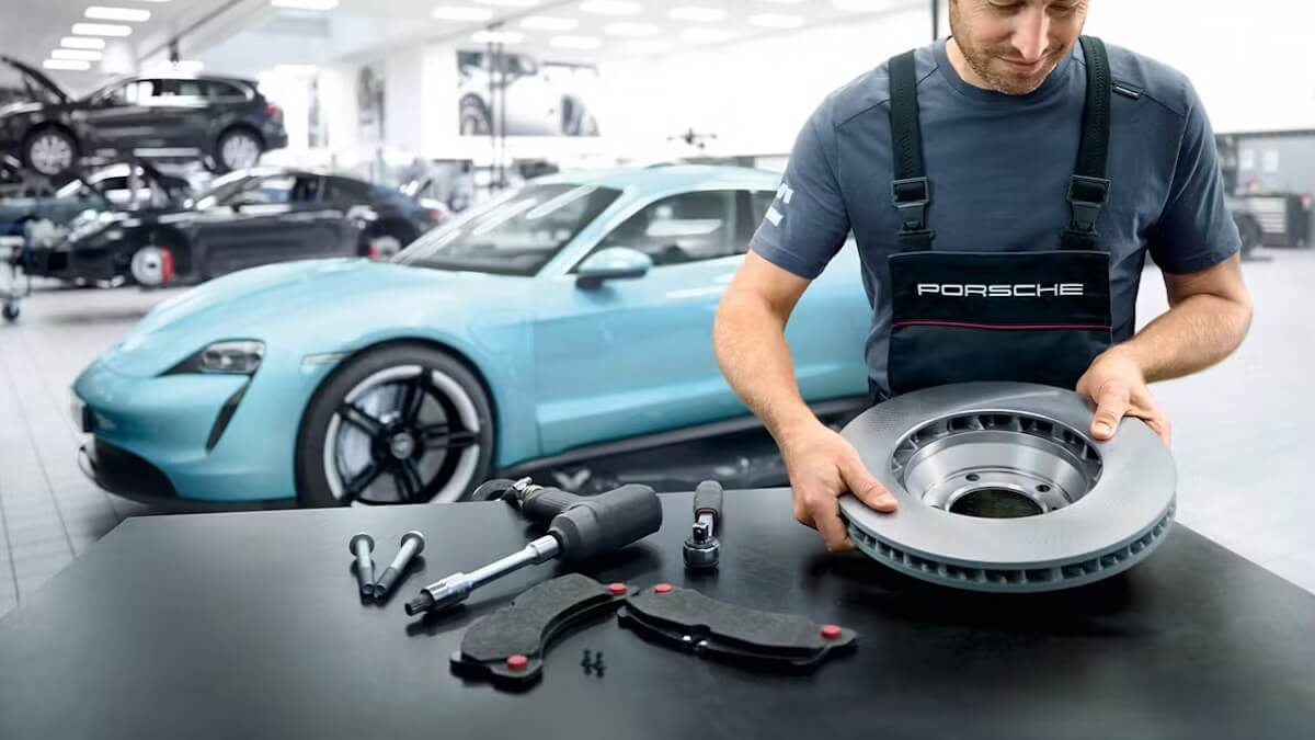Porsche technician holding Porsche parts