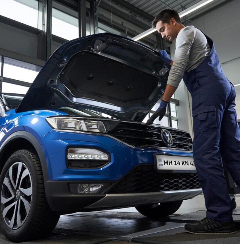 Technician examining a Blue Volkswagen SUV