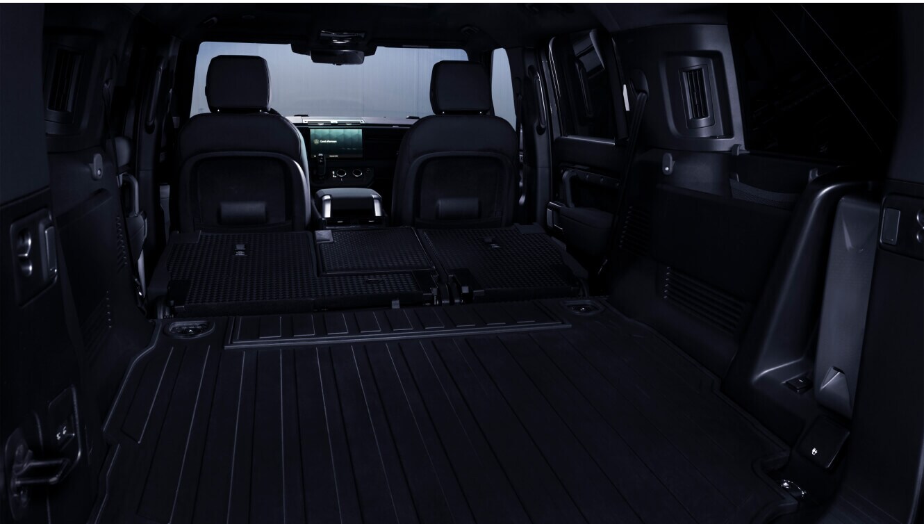 Expanded rear cargo area view of a Land Rover Defender 130 Outbound showing Ebony Resist interior.