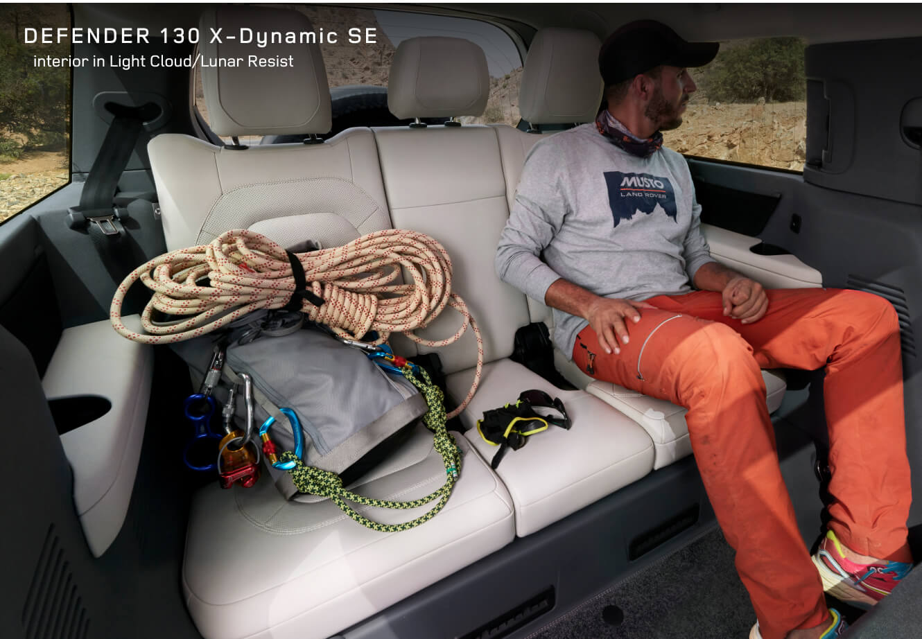 Interior third-row view of a Land Rover Defender 130 X-Dynamic SE showing Light Cloud and Lunar Resist interior.