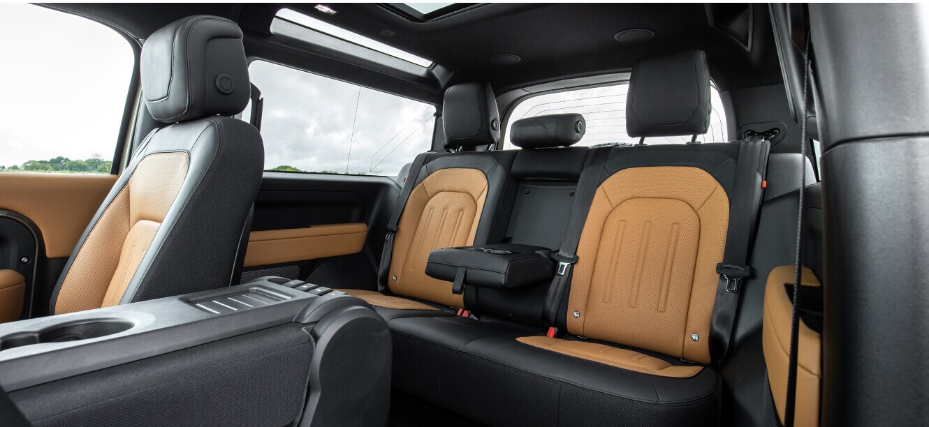 Interior rear passenger row view of a Land Rover Defender 90 S showing Caraway Windsor interior.