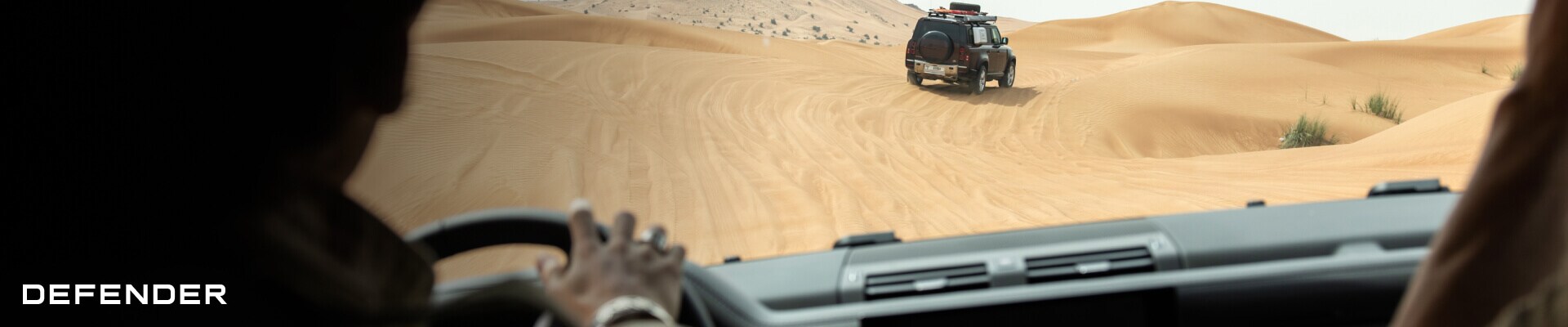 Driver's point-of-view perspective inside a Land Rover Defender 130 SE in Ebony showing its premium fabric dashboard.