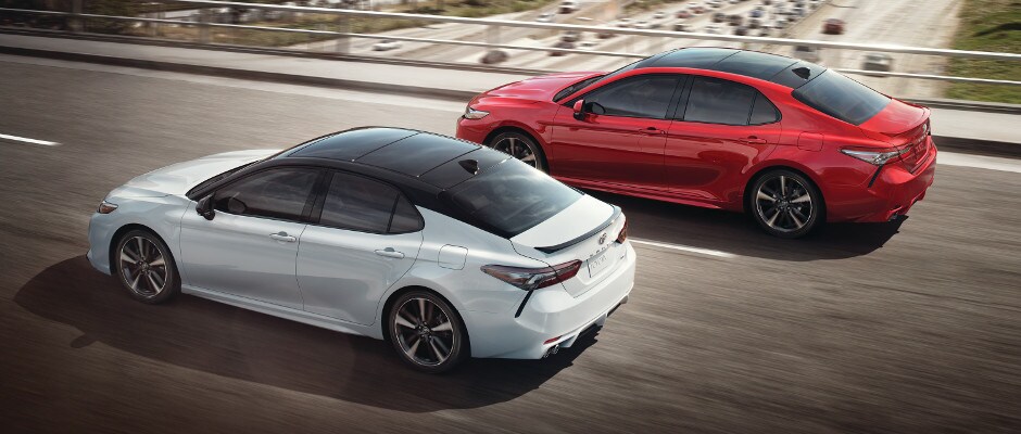 Test drive a 2018 Toyota Camry today! A white and red Toyota Camry driving down a highway