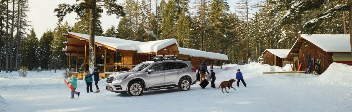 2019 silver subaru ascent in the snow by a cabin