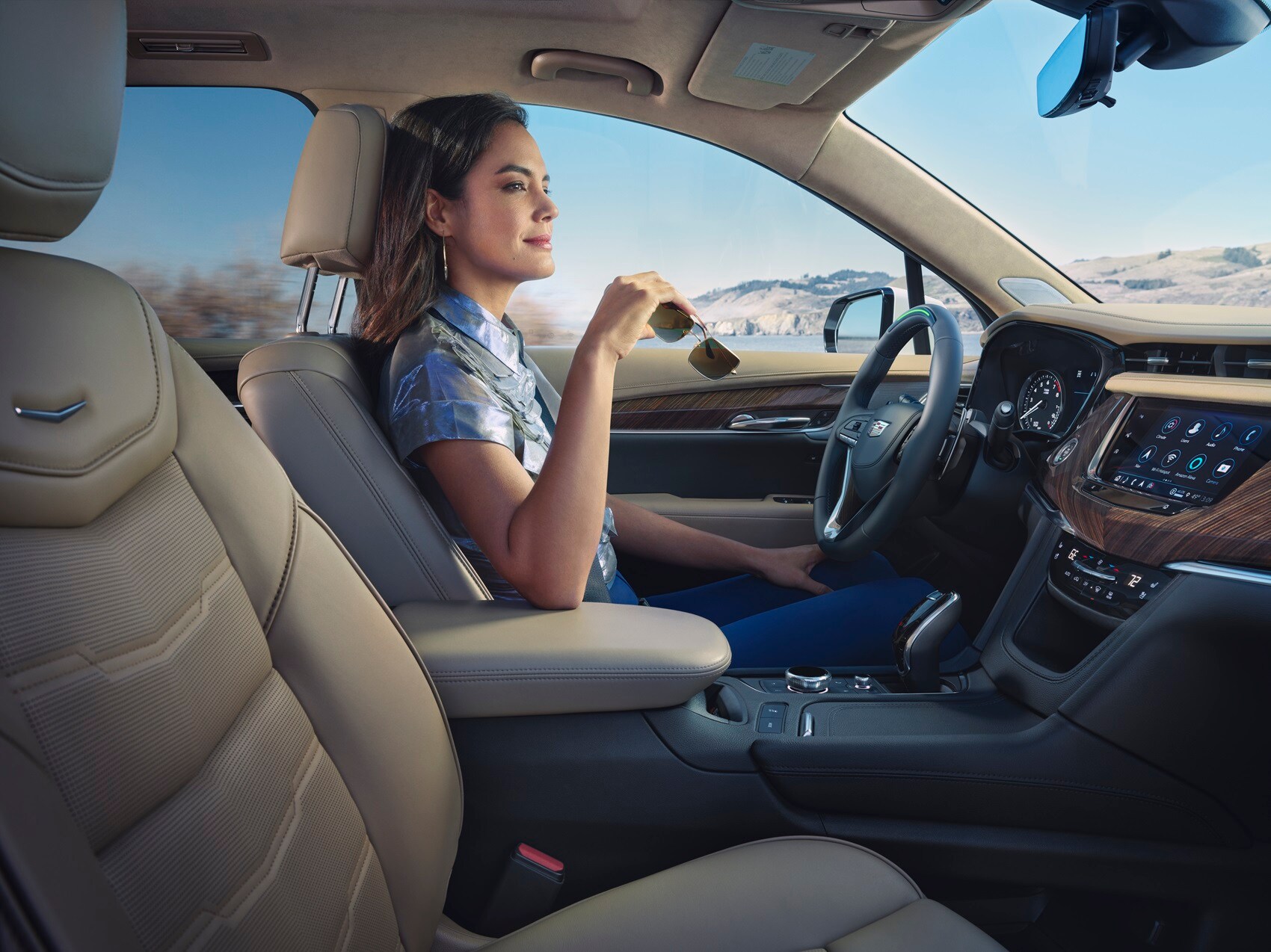 Woman sitting inside parked Cadillac car enjoying the view