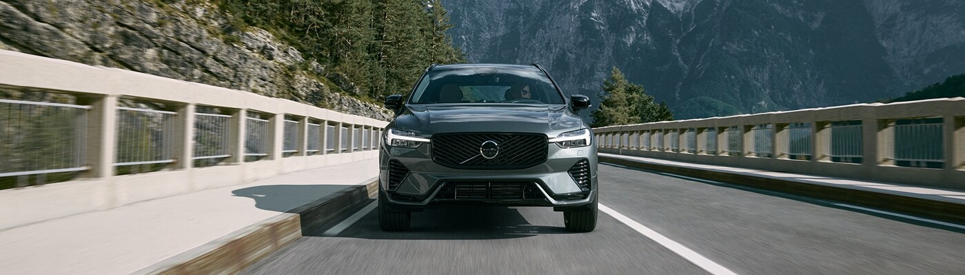 Volvo XC60 Plug-In Hybrid Volvo XC60 Plug-In Hybrid driving away from mountain range