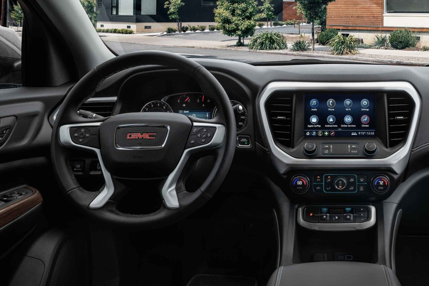 Close up interior comparison of the steering wheel and infotainment system inside the 2023 GMC Acadia SUV