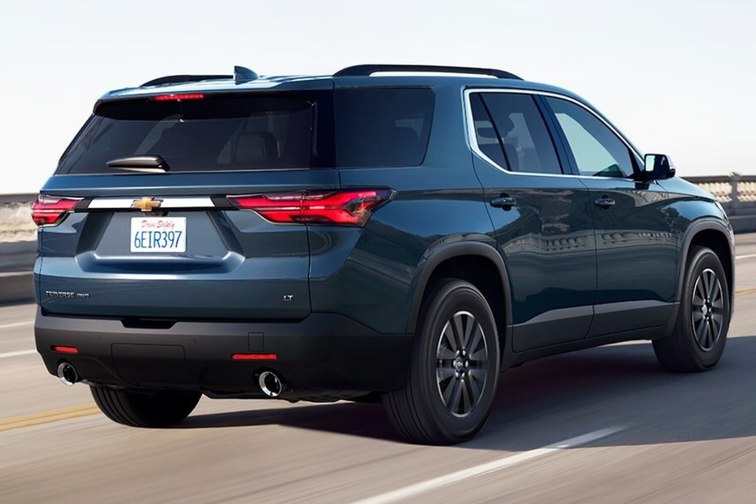 Rear exterior comparison of a blue 2023 Chevrolet Traverse midsize SUV