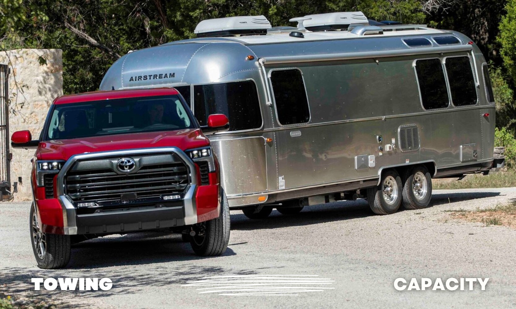 a used red Toyota Tundra truck showing off its towing power by easily pulling a large Airstream trailer behind it