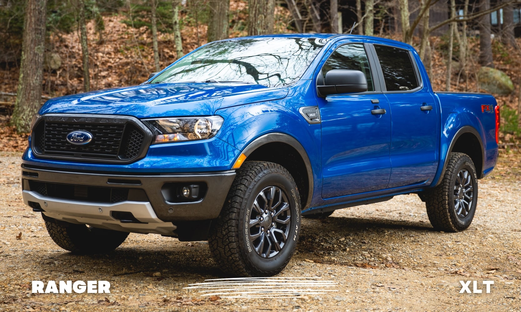 Front driver side profile view of a blue Ford Ranger XLT truck parked on a rocky dirt forest road