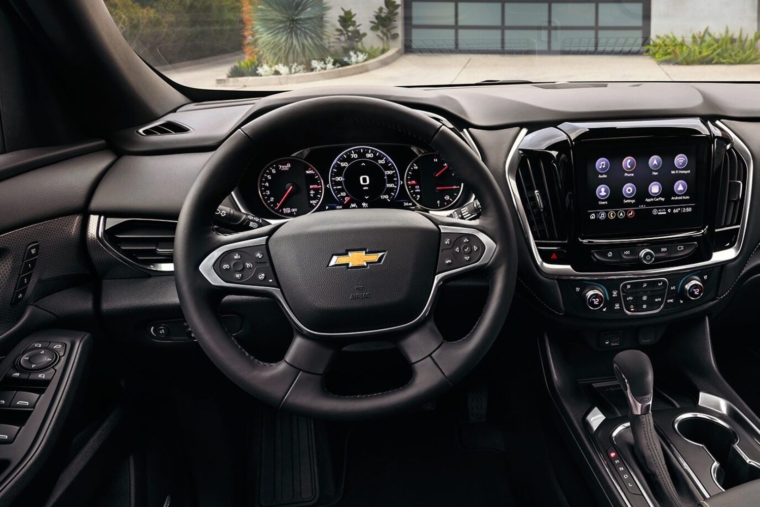 Close up interior comparison of the steering wheel and infotainment system inside the 2023 Chevy Traverse SUV