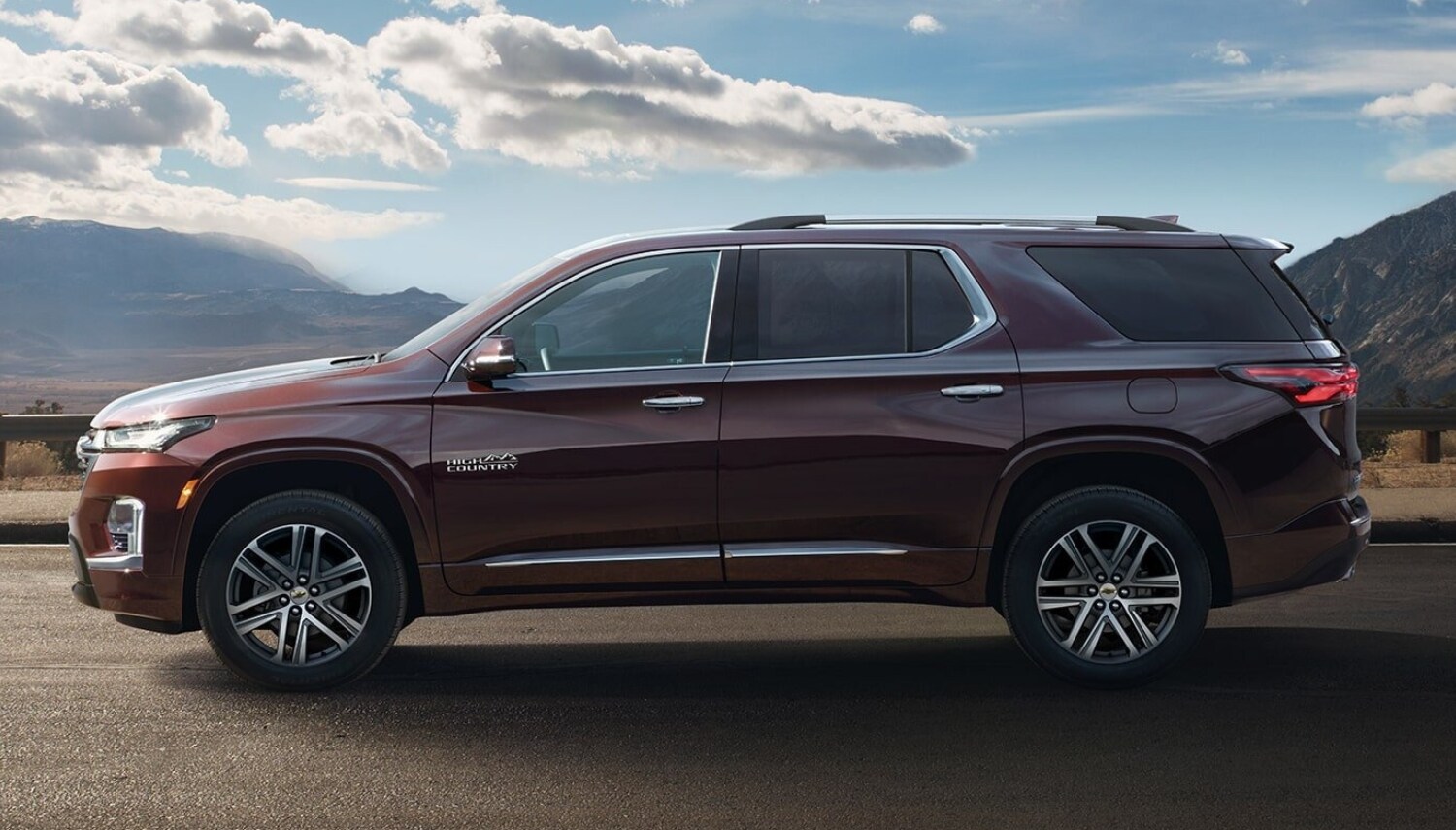 Exterior view of a 2023 Chevy Traverse midsize SUV driving down an open country road
