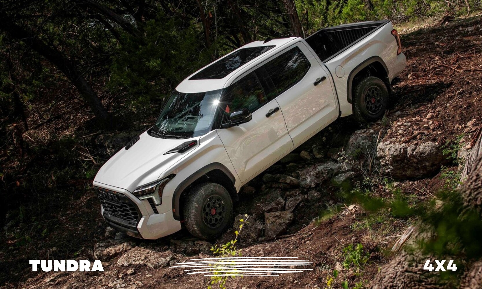 a white used 4x4 Toyota Tundra TRD Pro truck driving off-road down a steep rocky hill in a forest