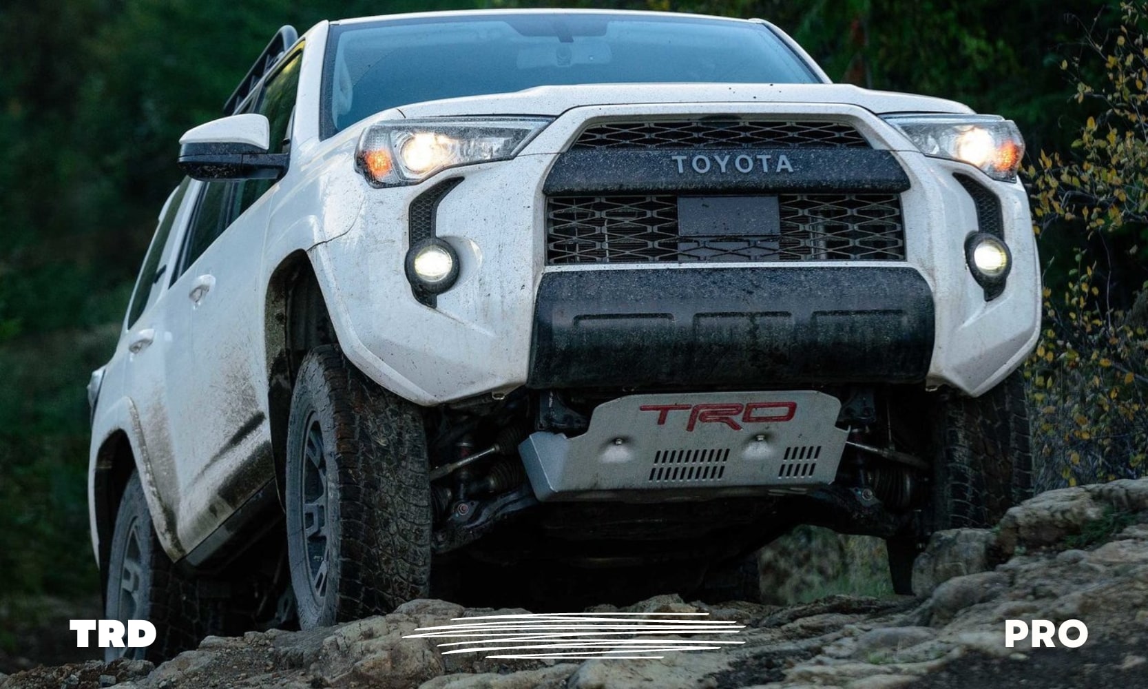 Image of a white used Toyota 4Runner TRD Pro SUV on an off-road trail climbing over a rocky hill