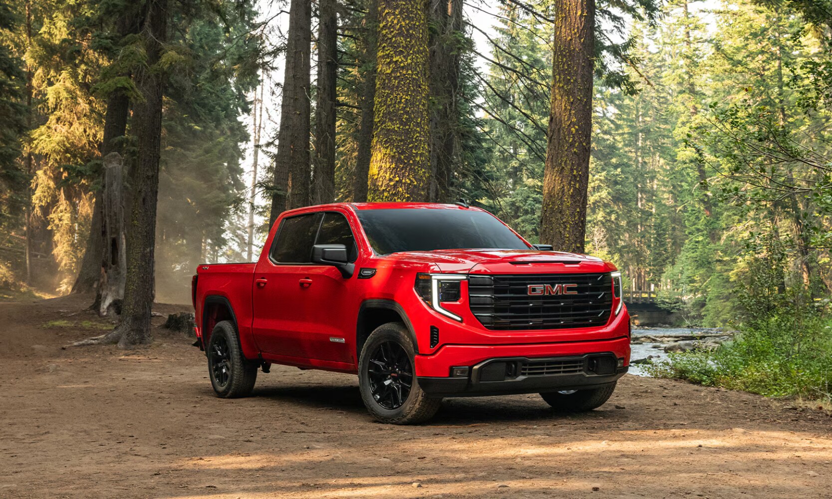 2026%20GMC%20Sierra%201500%20Elevation%20-%20Octane%20GMC%20of%20Santa%20Fe.png Exterior front angle image of a red 2026 GMC Sierra 1500 Elevation parked in a forest
