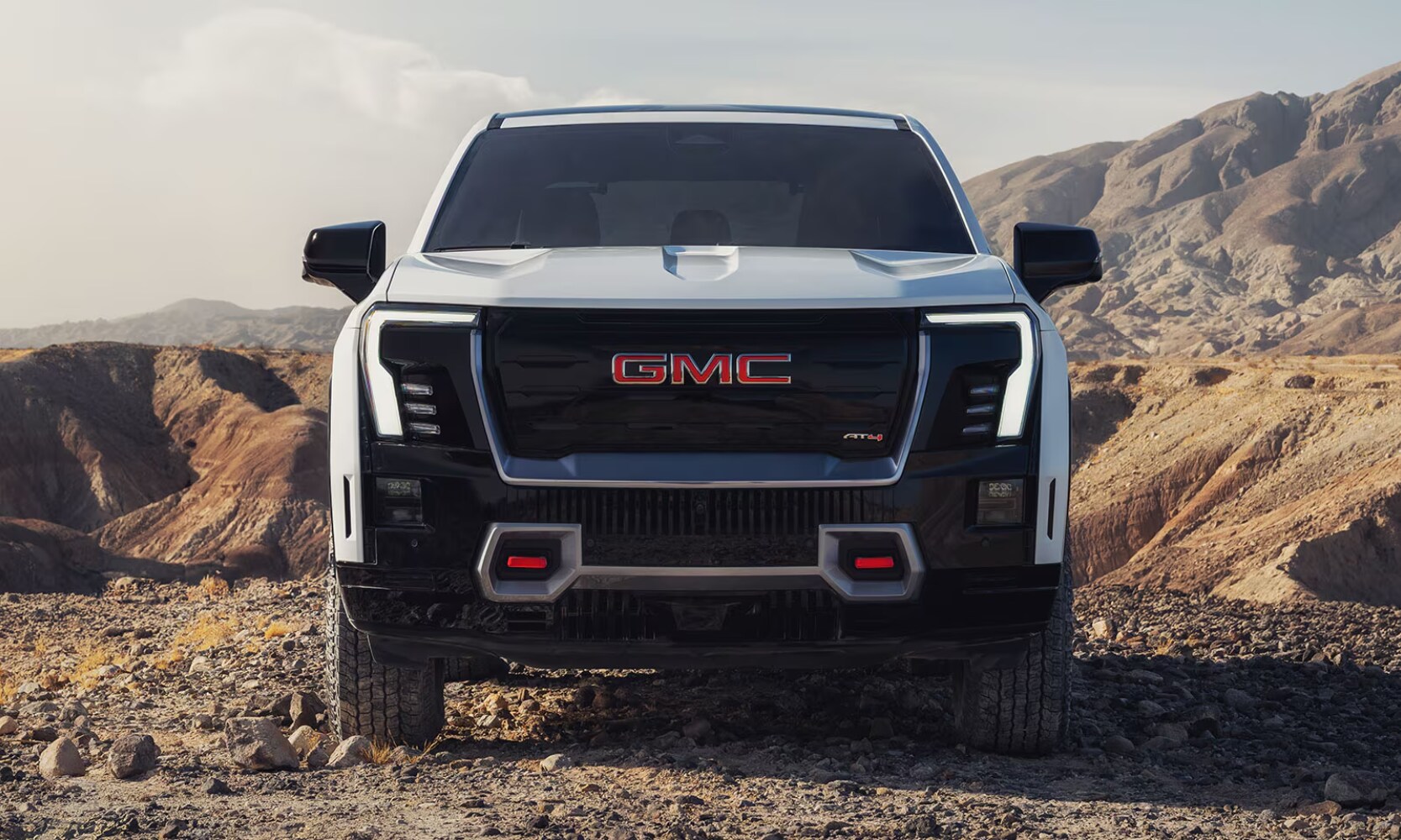 2026%20GMC%20Sierra%20EV%20AT4%20-%20Octane%20GMC%20of%20Santa%20Fe.png Exterior front image of a 2026 GMC Sierra AT4 parked in a rocky mountain landscape