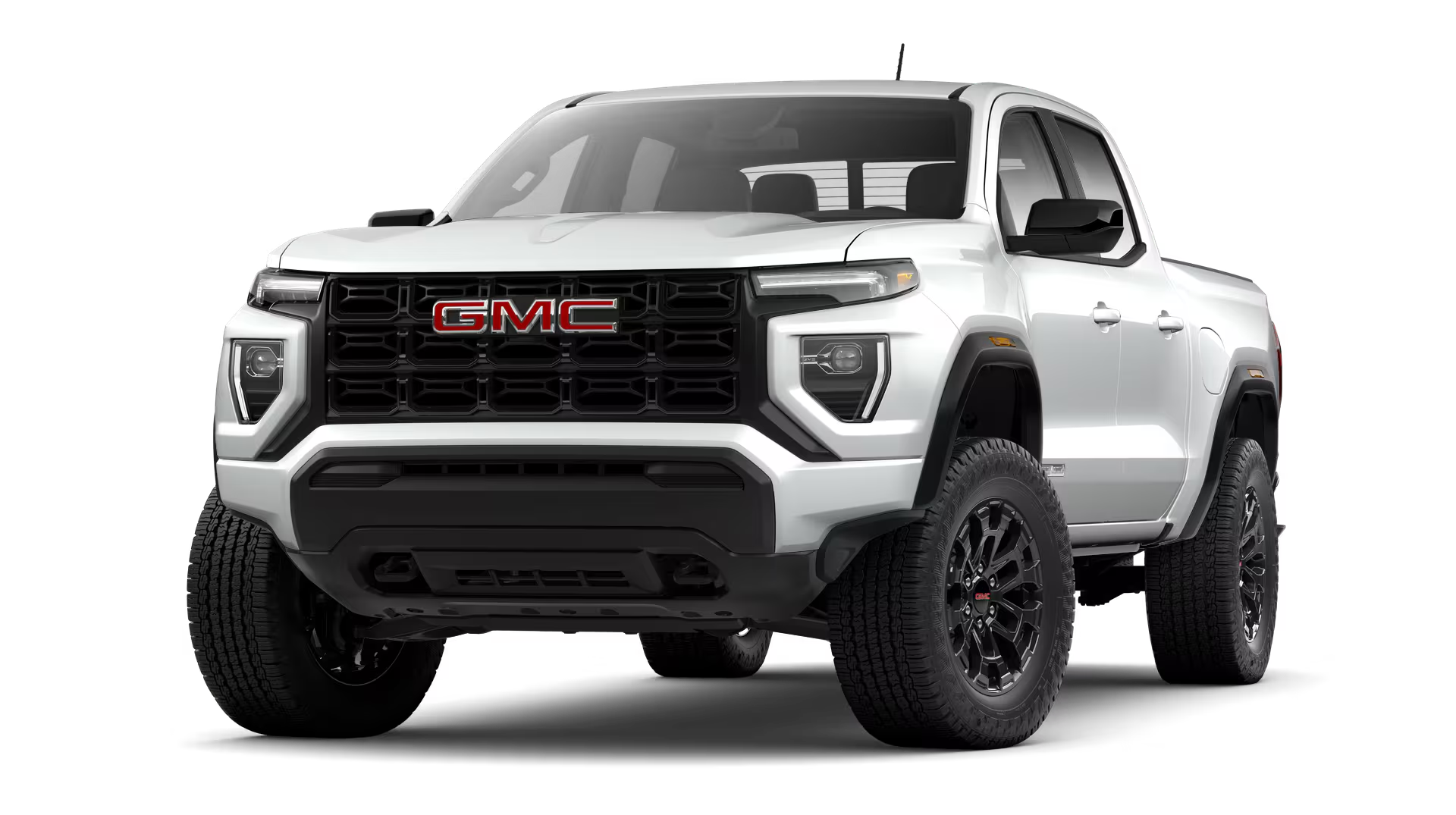 Exterior hero image of a black 2026 GMC Canyon Denali driving on a tree and hillside freeway