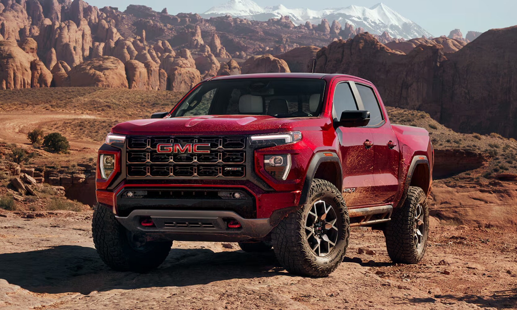 2026%20GMC%20Canyon%20AT4X%20-%20Octane%20GMC%20of%20Santa%20Fe.png Exterior front angle image of a red 2026 GMC Canyon AT4X parked in a mountainous landscape