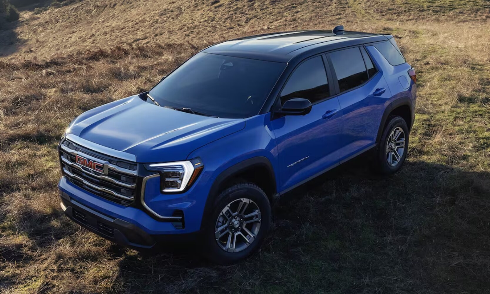 2026%20GMC%20Terrain%20Elevation%20-%20Octane%20GMC%20of%20Santa%20Fe.jpg Exterior front top-view image of a blue 2026 GMC Terrain parked in a grass field