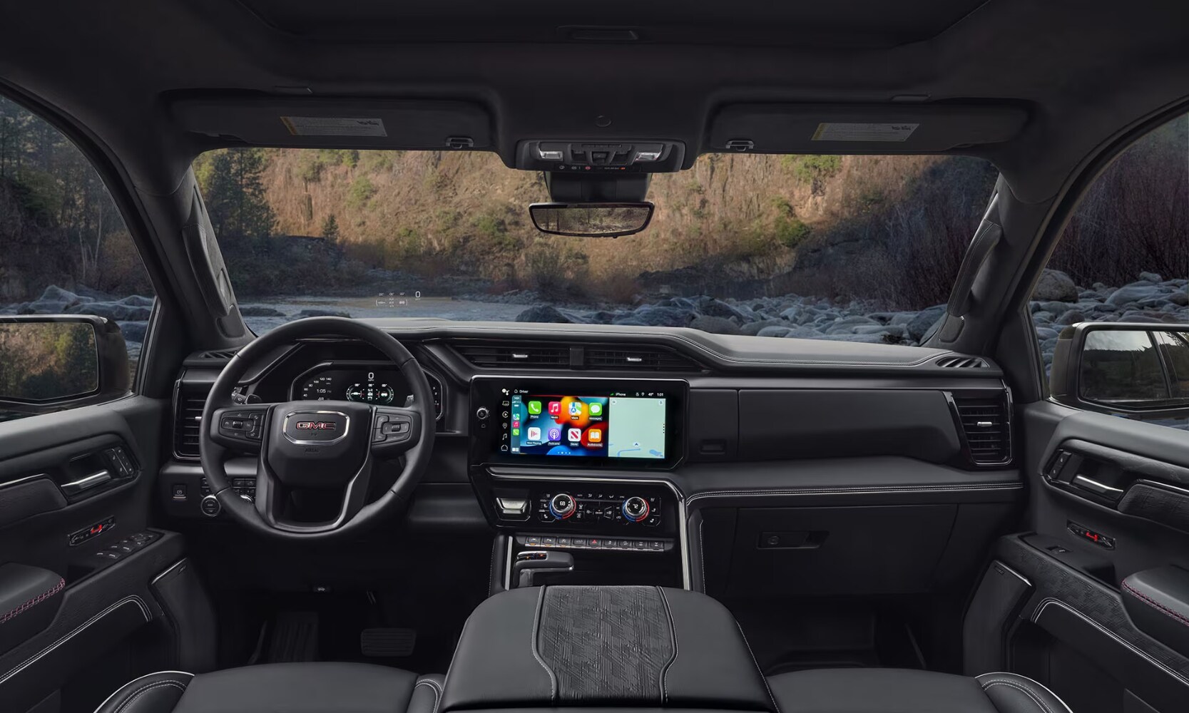 2025%20GMC%20Sierra%201500%20vs.%202025%20RAM%201500%20-%202025%20GMC%20Sierra%201500%20Interior%20-%20Octane%20GMC%20of%20Santa%20Fe.jpg Interior image of a 2025 GMC Sierra 1500 front seating area and infotainment system with rocky landscape views